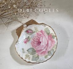 a white plate with pink flowers painted on it