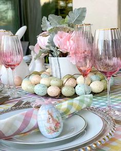 an easter table setting with pink flowers and eggs