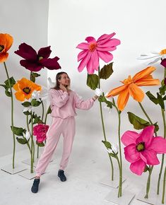 a woman standing in front of some fake flowers