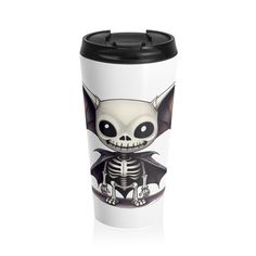 a white cup with a black lid and a skeleton on the front, sitting in front of a white background