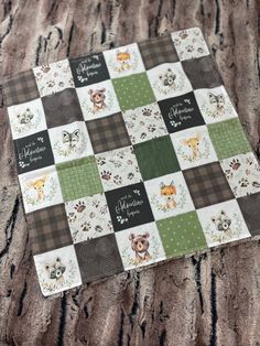 a close up of a patchwork quilt with animals on it and the words merry christmas written in cursive writing