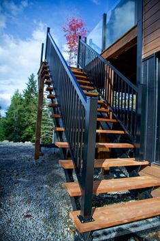 a set of wooden stairs leading up to a building with metal railings and handrails