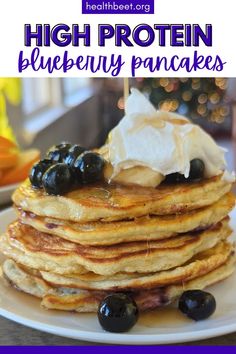 a stack of pancakes with blueberries and whipped cream on top is shown in this image