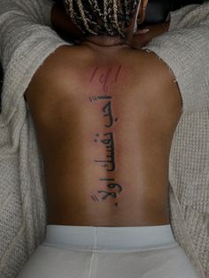 the back of a woman's body with writing on it