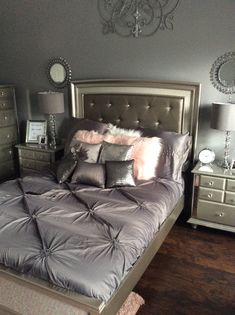 a bedroom with a bed, dressers and mirror on the wall above it's headboard