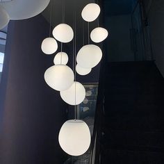 a bunch of lights hanging from the ceiling in a room with black walls and stairs