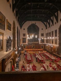 an empty dining hall with tables and red chairs