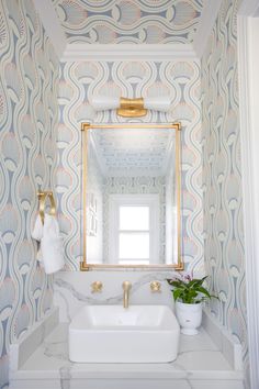 a white sink sitting under a bathroom mirror next to a wall mounted faucet