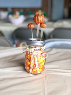 a jar filled with candy corn on top of a table