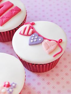 three decorated cupcakes sitting on top of a table