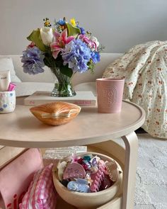 a table that has some flowers on it and other things in the bowl next to it