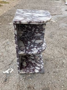 a marble shelf sitting on top of a gravel road