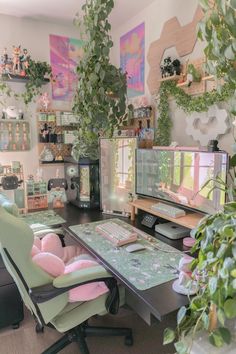 a desk with a computer monitor, keyboard and stuffed animal on it in front of some plants