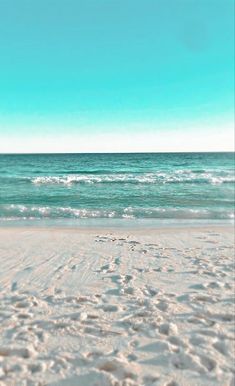 an empty beach with footprints in the sand