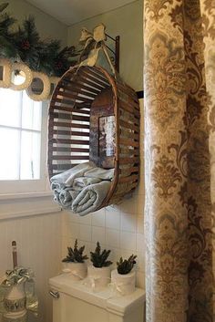 a bathroom with a toilet, mirror and christmas decorations on the window sill above it