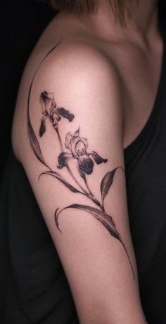 a woman's arm with flowers and leaves tattooed on the left side of her arm