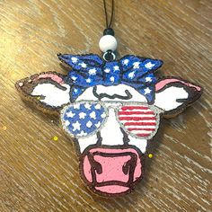 an ornament shaped like a cow with sunglasses and stars on it's head