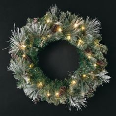 a christmas wreath with pine cones and lights