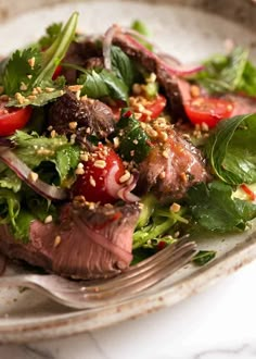 a close up of a plate of food with meat and veggies on it