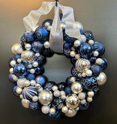 a blue and silver christmas ornament wreath hanging on a wall