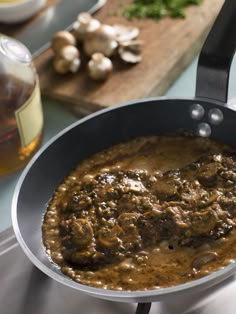 a pan filled with food sitting on top of a stove next to a cutting board