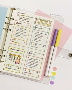 an open planner with two pens on top of it next to some sticky notes and markers