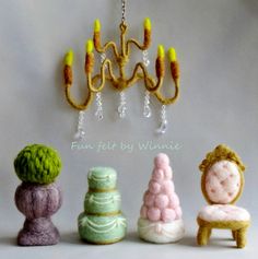 four small knitted objects are sitting in front of a chandelier