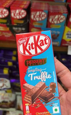 a person holding up a kitkat chocolate bar