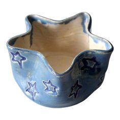 a blue and white ceramic bowl with stars on the inside, sitting in front of a white background