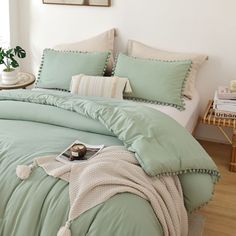 a bed with green sheets and pillows in a room