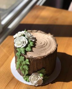 a chocolate cake decorated with flowers on a wooden table