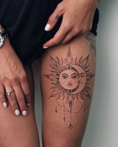 a woman's thigh with a sun and moon tattoo on her left side leg