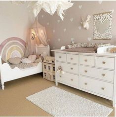 a baby's room with white furniture and hearts on the wall