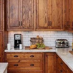 a kitchen with wooden cabinets and white marble counter tops