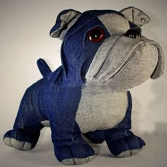 a stuffed animal dog is shown in blue and grey denims with an orange eye