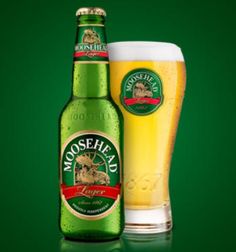 a glass and bottle of beer sitting next to each other on a green tablecloth