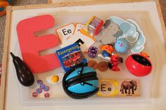 there is a tray with toys and letters on it