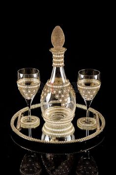 a wine glass and decanter set on a black background