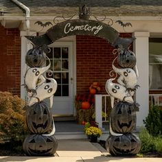 two halloween decorations on top of pumpkins in front of a building with a sign that says cemetery