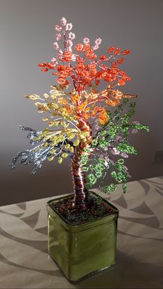 a colorful tree in a green container on a table