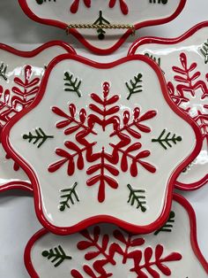 three red and white plates with snowflakes on them, one has a chain hanging from it