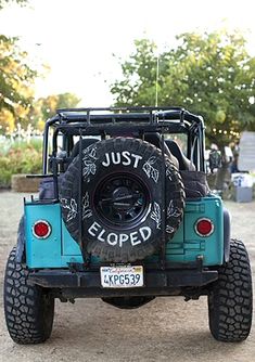 a blue jeep parked on top of a dirt field