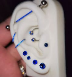 a close up of a person's ear with blue and white beads on it