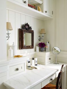 a white desk topped with a mirror next to a chair