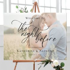 an easel with a sign that says welcome to the night before and flowers on it