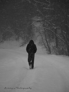 a person walking through the snow in front of some trees