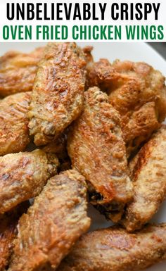 chicken wings on a white plate next to broccoli and lettuce leaves