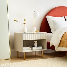 a bedroom with a bed, nightstand and mirror