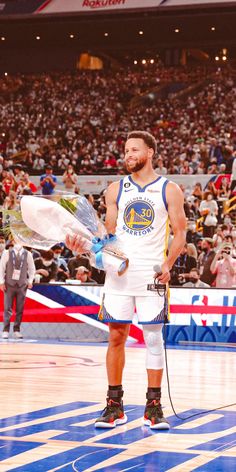 a man holding a basketball in front of a crowd