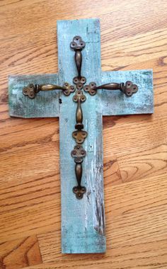 an old wooden cross with metal handles on a wood floor in front of a wall